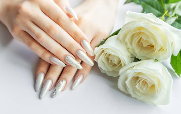 istock Female Hands on a white background with beautiful pearl manicure 2159526222