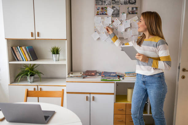 istock Happy woman holding digital tablet while analyzing notes at home office 2159527214