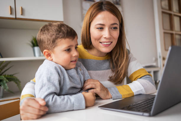 istock Happy mother with son working on laptop at home 2159527640