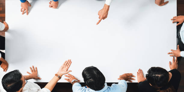istock Businesspeople on meeting table pointing to empty space. Prudent 2159529909