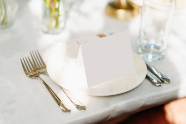 Baptism are not always held in church. Some families prefer to celebrate in the confort of their own backyard, with a family member as the celebrant. A lighted candle is burning on a decorated table with glasses of wine. Horizontal outdoors shot with no people and copy space.