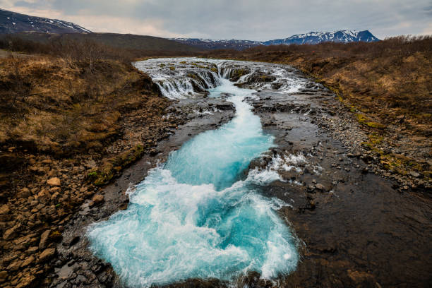 istock Bruarfoss Waterfall in Iceland with vibrant blue waters and a rugged landscape. 2159545530
