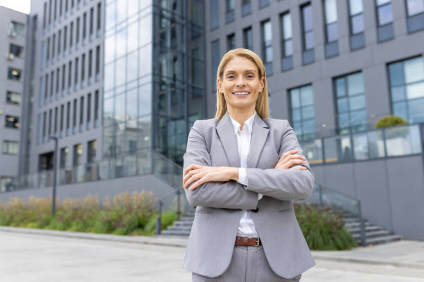 istock Confident businesswoman standing outside modern office building 2159547085