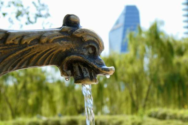 The ornate Scott Fountain on Belle Isle Park, Detroit. This is a public fountain, completed in 1925 as an eponymous tribute. In the background, the skyline of Detroit.