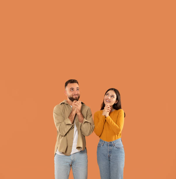 istock Man and Woman Smiling on Orange Backdrop, Copy Space Above 2159555805