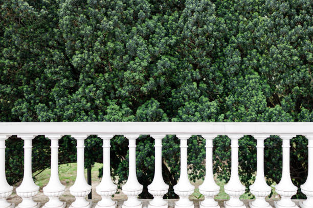 a white fence is a fence in the park, the background is a green plant. beautiful concrete fence