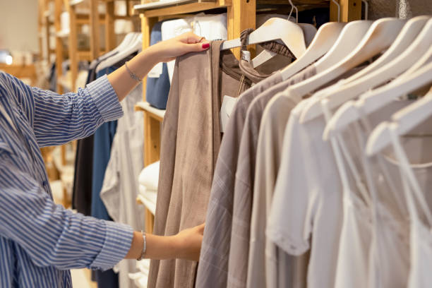 istock Female hand taking a clothes out at clothing store 2159558133
