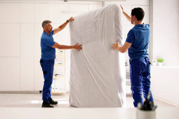 istock Delivering Comfort: A professional mover in a white uniform carrying a mattress 2159561867