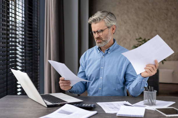 istock Focused businessman reviewing documents at his desk 2159561954