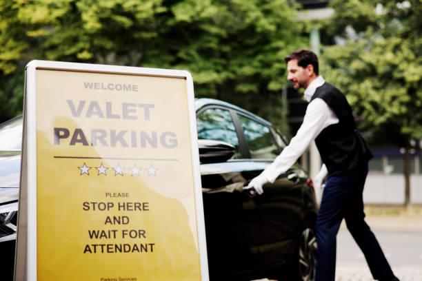 istock Luxury Car Pickup: Businessman Smiling as Valet Hands Over Key in Urban Setting 2159562011