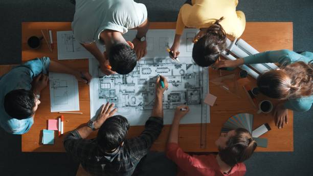 istock Top down view of engineer team writing at blueprint at meeting table. Symposium. 2159565742