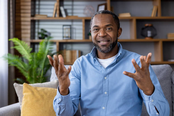 istock Man in blue shirt talking during a video call at home, feeling engaged and expressive 2159568187