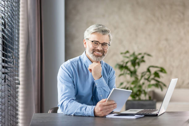 istock Office professional with tablet working remotely in home office 2159568415