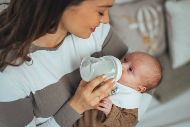 istock Caring Mother Feeding Newborn with Bottle 2159568962