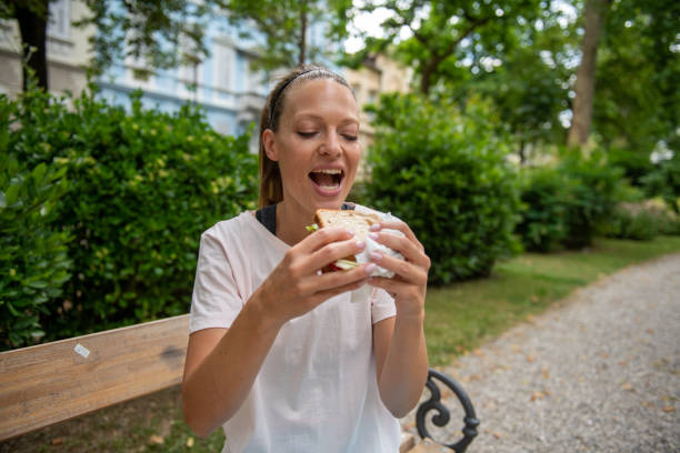 Cheerful man eating a slice of pizza with the iconic Colosseum in the background, immersed in a delightful culinary experience in Rome. Copy space.