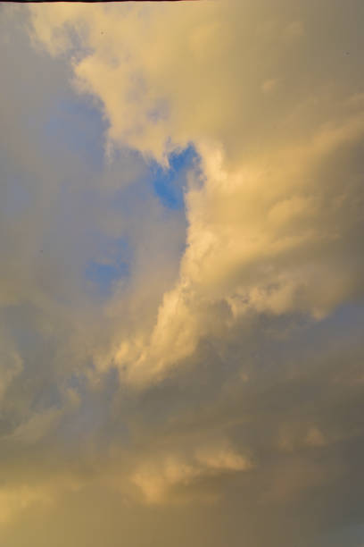 Yellow-blue gray clouds in the evening summer sky. Cumulus clouds.