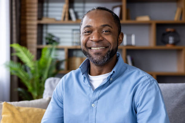 istock Smiling man sitting at home, looking at the camera 2159573638