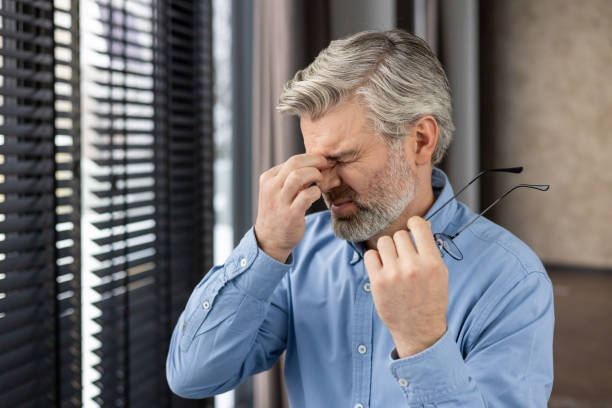 istock Mature man experiencing headache and stress at work while holding his glasses 2159574818