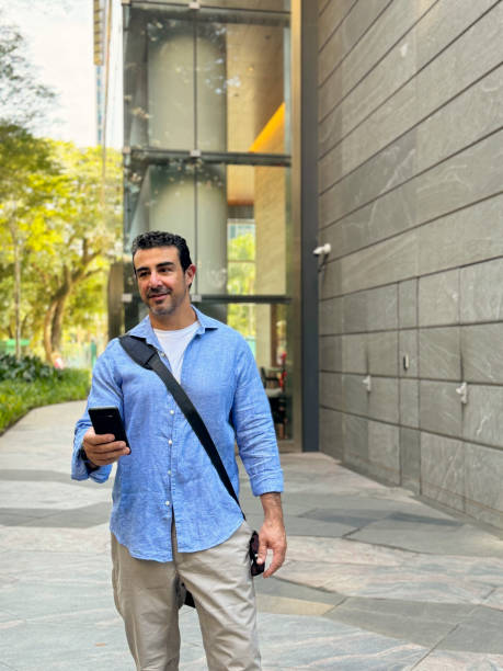 istock Mature man using cell phone on the outside of a corporate building 2159580118