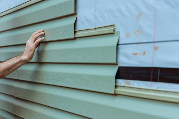 Contractor installing vinyl siding plastic panels on facade wall of a new home