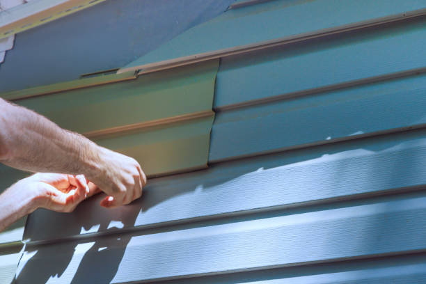 istock Workers install vinyl plastic siding panels on wall facade of a new home during construction 2159580141