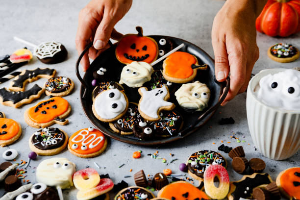 istock Hands creating Halloween display with homemade gingerbread cookies on kitchen table 2159581363