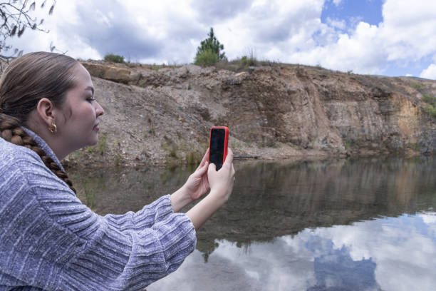 Young woman taking photos at a lake