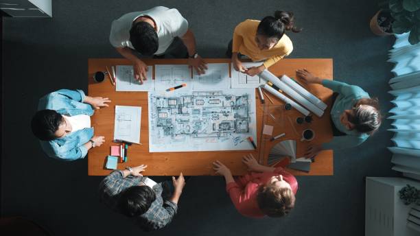 istock Top view of engineer team holding blueprint and standing at table. Symposium. 2159582196