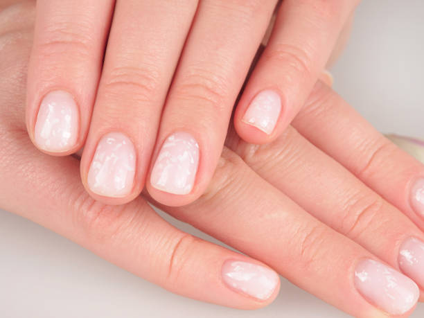 istock Women's manicure shellac soft pink color close-up 2159583737