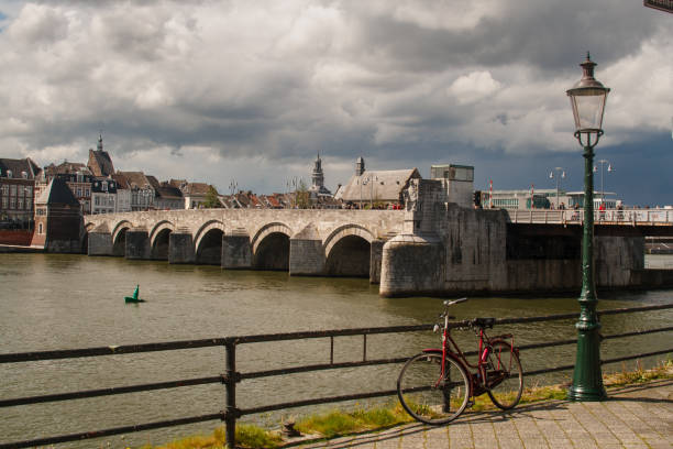 Een fiets geparkeerd tegen de Maas. Uitzicht op de Sint Servaasbrug