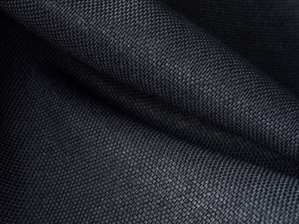 Dark fabric material, synthetic fiber texture, selective focus, dark background
