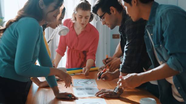 istock Top view of skilled designer holding logo while discussing with team. Symposium. 2159586126