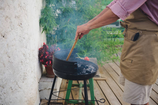 istock Man grilling outdoors with apron on a summer day 2159587087