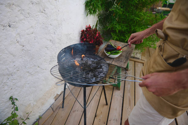 istock Man grilling vegetables on outdoor BBQ grill in backyard 2159587105