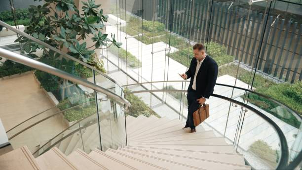 istock Skilled businessman analyzing marketing report data from mobile phone. Urbane 2159587139