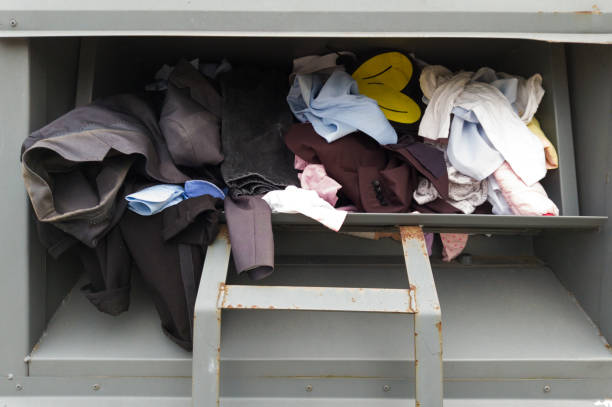 istock Mixture of different clothing items inside a metal donation bin for recycling. 2159587364