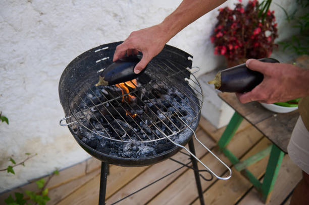 istock Man grilling eggplants on a charcoal barbecue outdoors 2159587425