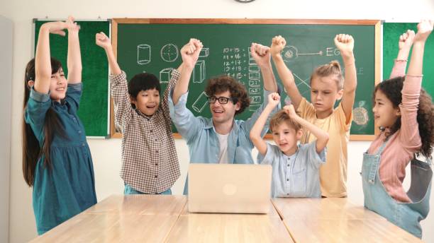 istock Teacher and student looking at laptop while celebrate success project. Pedagogy. 2159589065