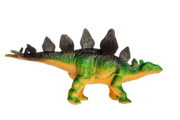 Small and cute plastic stegosaurus toy on cyan background