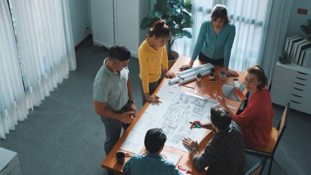istock Professional engineer team writing at blueprint at meeting table. Symposium. 2159590662