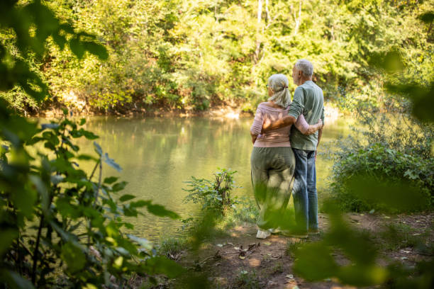istock Elderly Couple Embracing by the River 2159590821