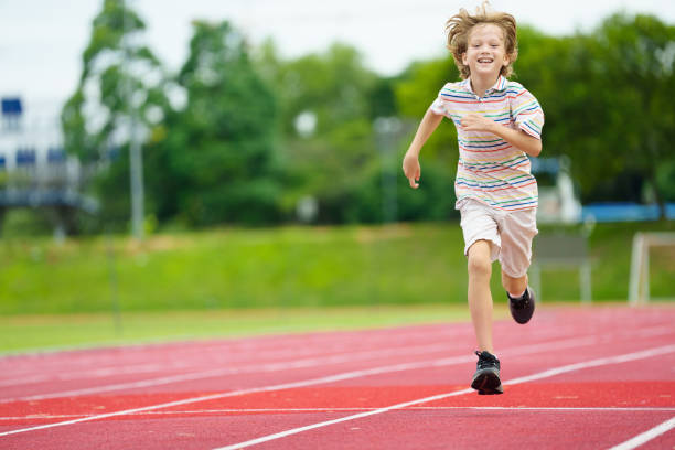 istock Child exercising. Kid running on stadium. 2159590875