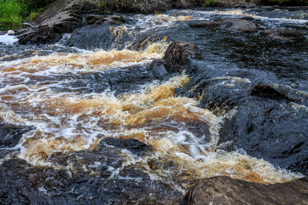 a bubbling fast cold river with cliffs and waterfalls, a mountain river with rapids