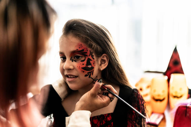 Children girl doing Halloween makeup at home