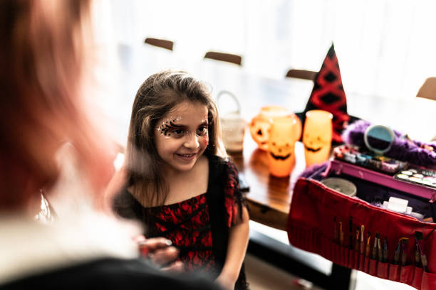 Children girl doing Halloween makeup at home