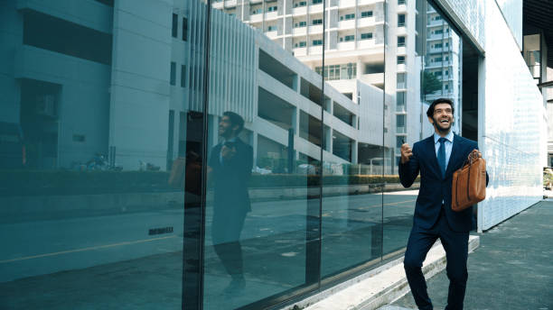 istock Skilled business man dancing with joyful while walking in glass wall. Exultant. 2159599547