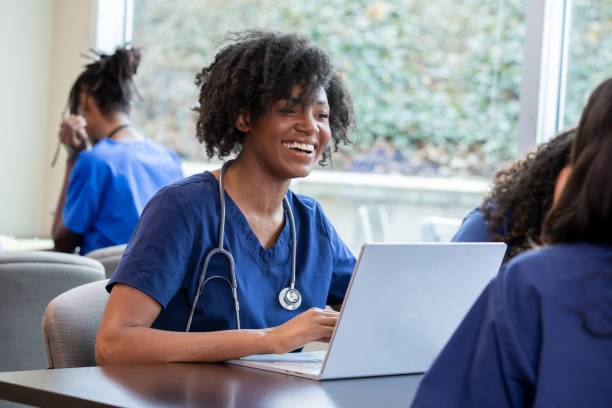 istock Engaged in the classroom setting, a student dressed in scrubs employs her laptop as a dynamic tool for active learning, skillfully documenting important concepts and contributing thoughtfully to the collective discourse. 2159601078