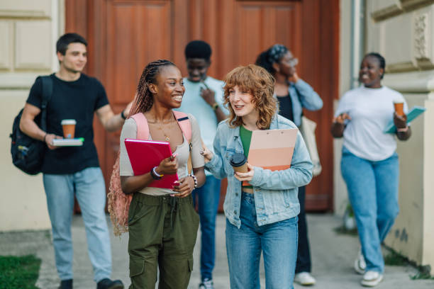 istock Diverse college students exiting university building and going on break 2159601235