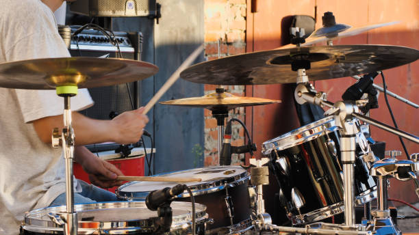 A black drum set, complete with drumsticks, cymbals, and microphones