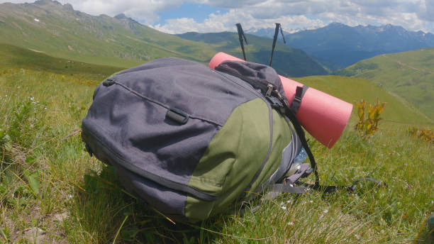 istock A rucksack with a hiking mat and poles lying on a mountainside 2159601708